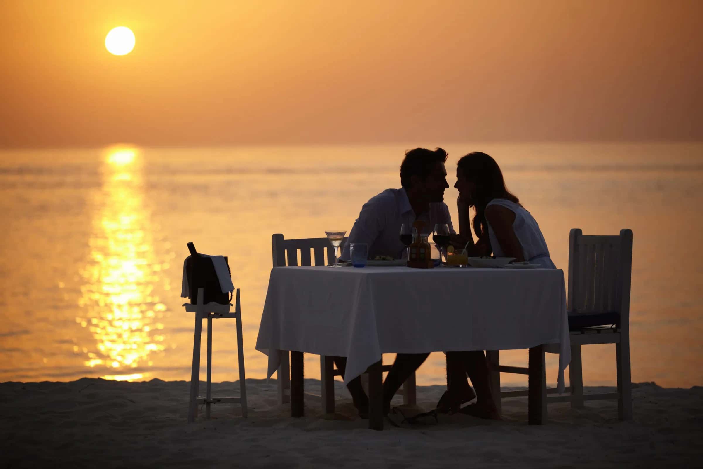 Flitterwochen: romantisches Dinner zu zweit am Meer bei Sonnenuntergang