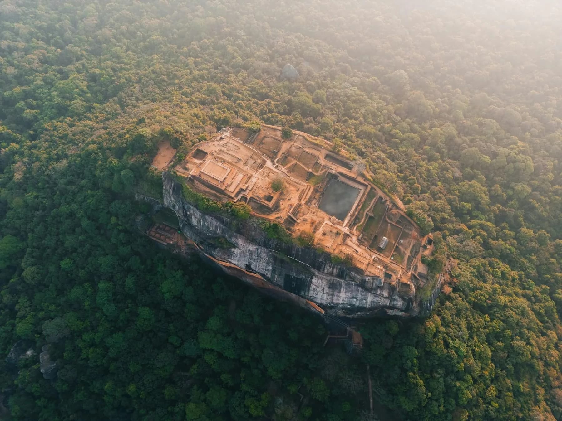 Der Löwenfelsen von Sigiriya ragt in der Dämmerung aus dem Dschungel