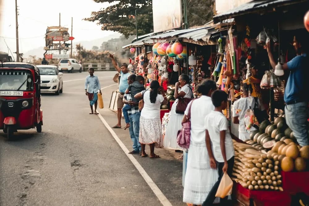 Straßenszene in Sri Lanka mit Tuk-Tuk und Obstständen am Straßenrand