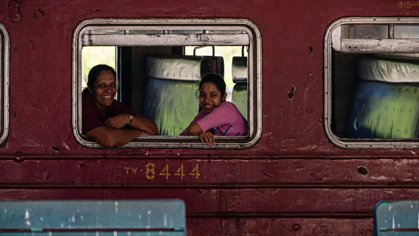Reisende schauen aus einem Zugfenster in Sri Lanka